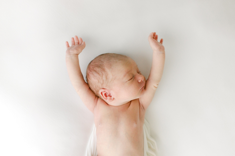 labor of love doula services image of newborn baby stretching