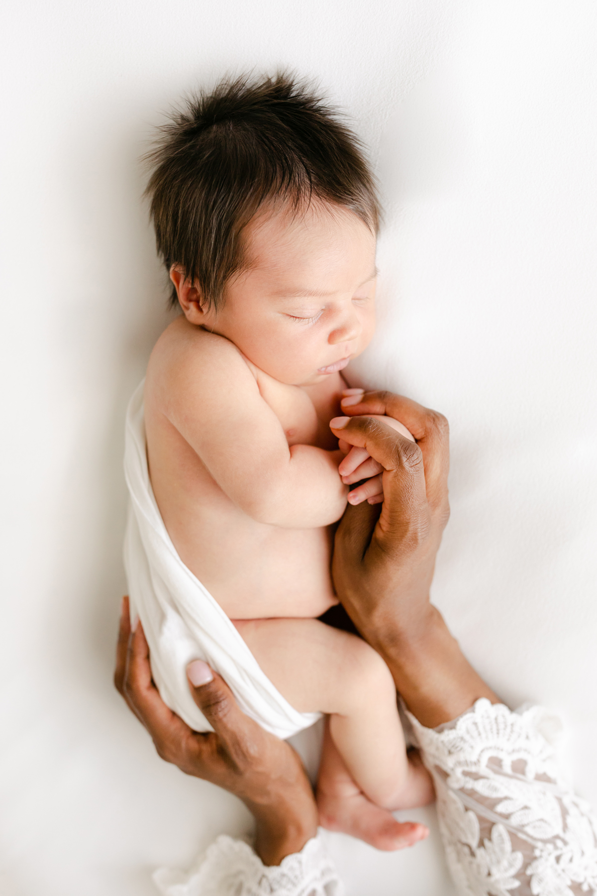 Birmingham newborn photographer baby in mom's hands on white background