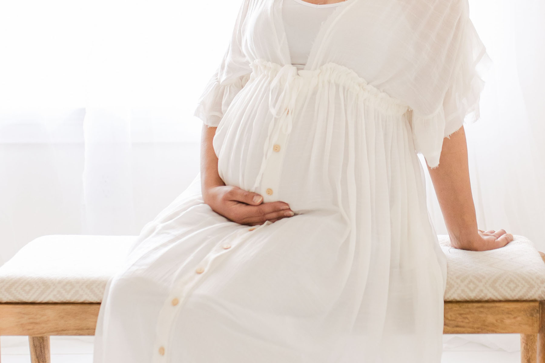 water birth in birmingham alabama maternity image of mom sitting on bench in a light drenched studio