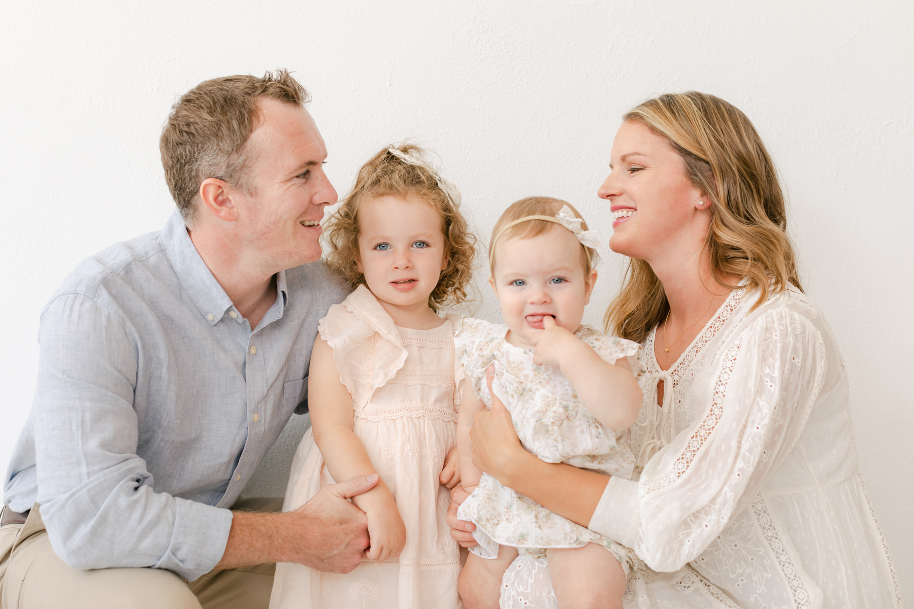 family photography in pike road family of four with two daughters hugging and smiling