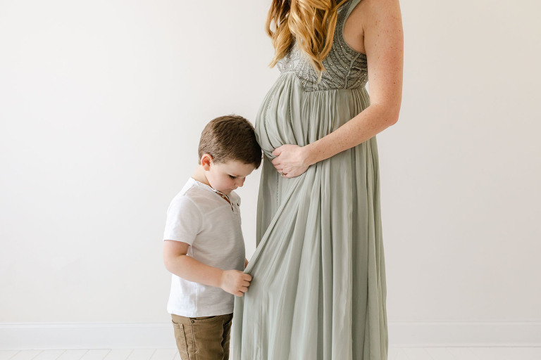 Image of an expecting mama and her son in a natural light studio near the waters in pike road AL