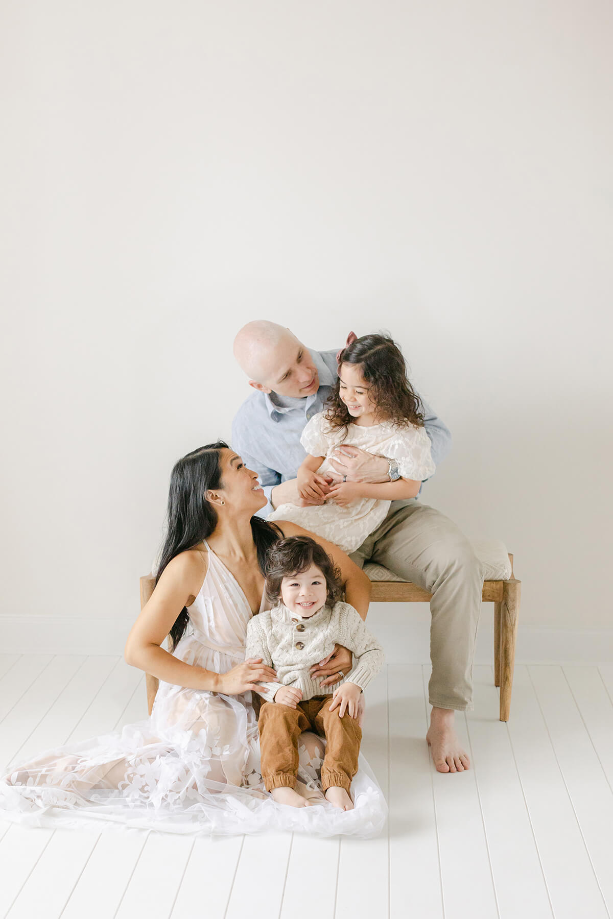 family of four snuggles on each other in omaha family photography studio