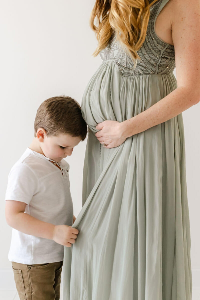 mom and little boy share a moment during a maternity photographer session