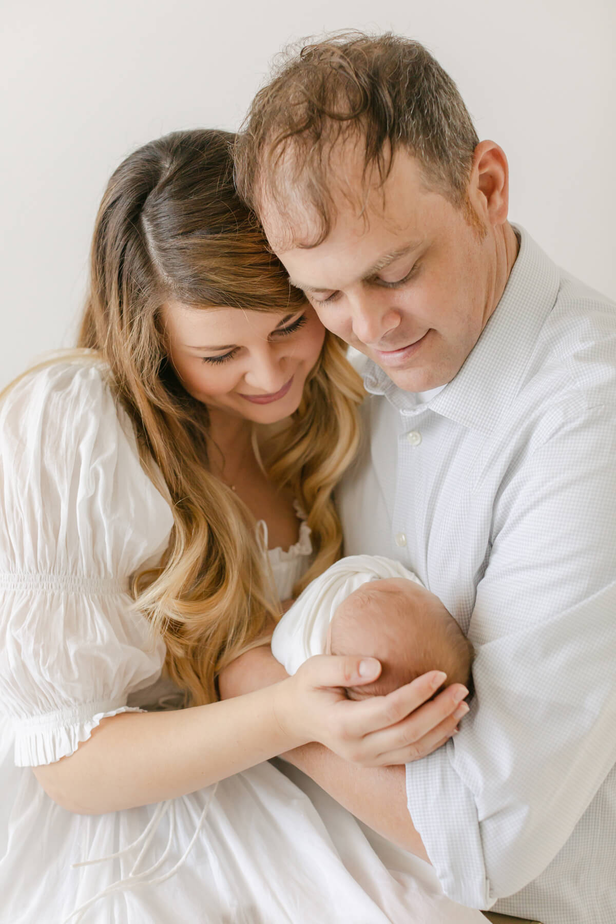 family admires their newborn baby in omaha nebraska photography studio