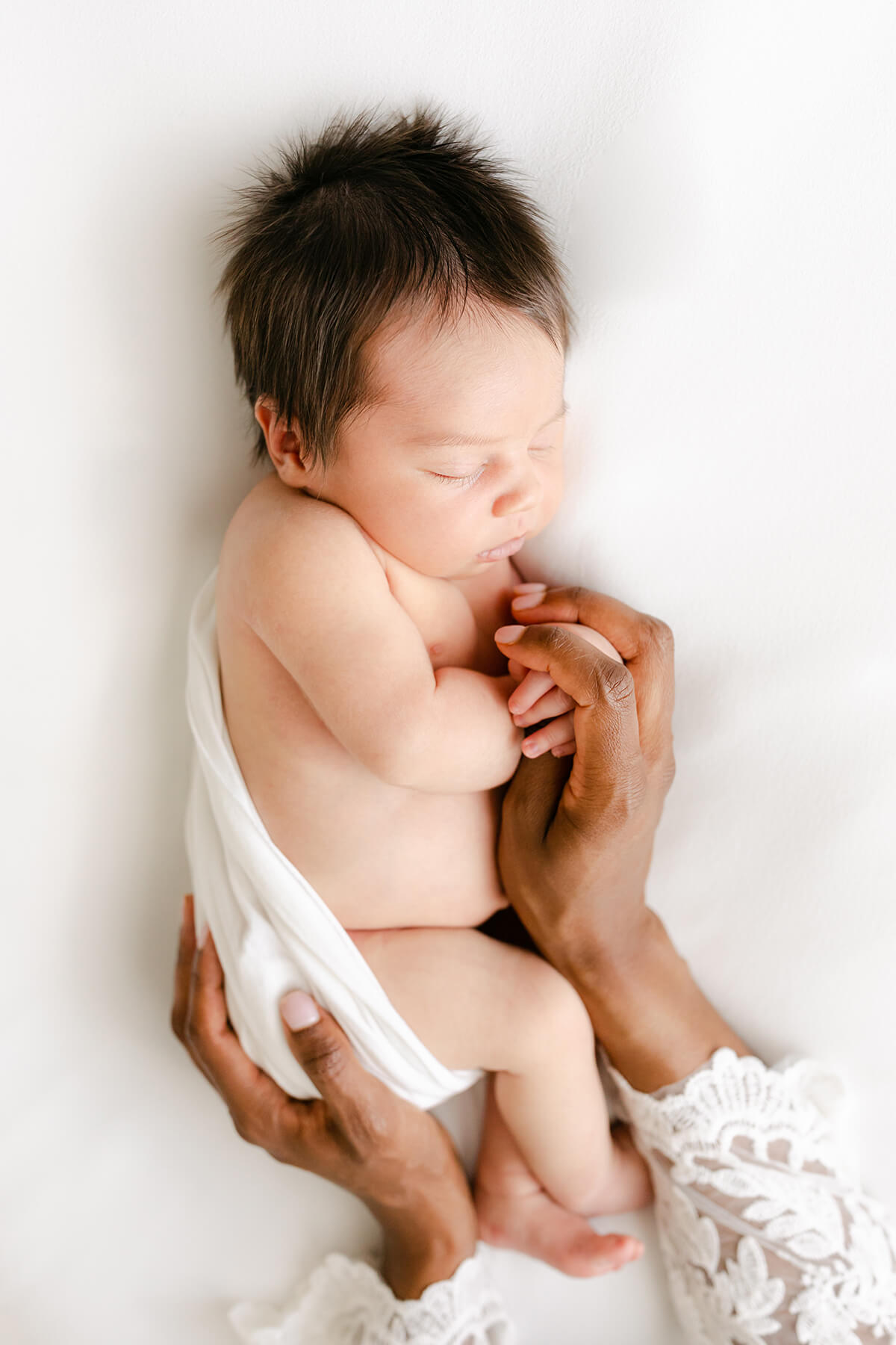 gorgeous dark skinned mom cradles multi racial baby in Omaha studio setting