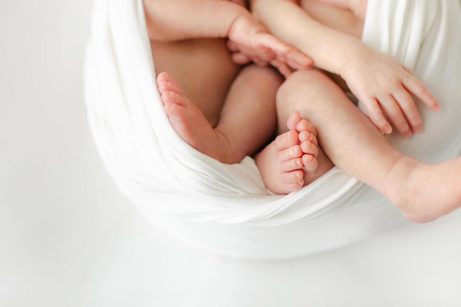 omaha twin newborn babies toes and hands memorialized in beautiful film like photography style