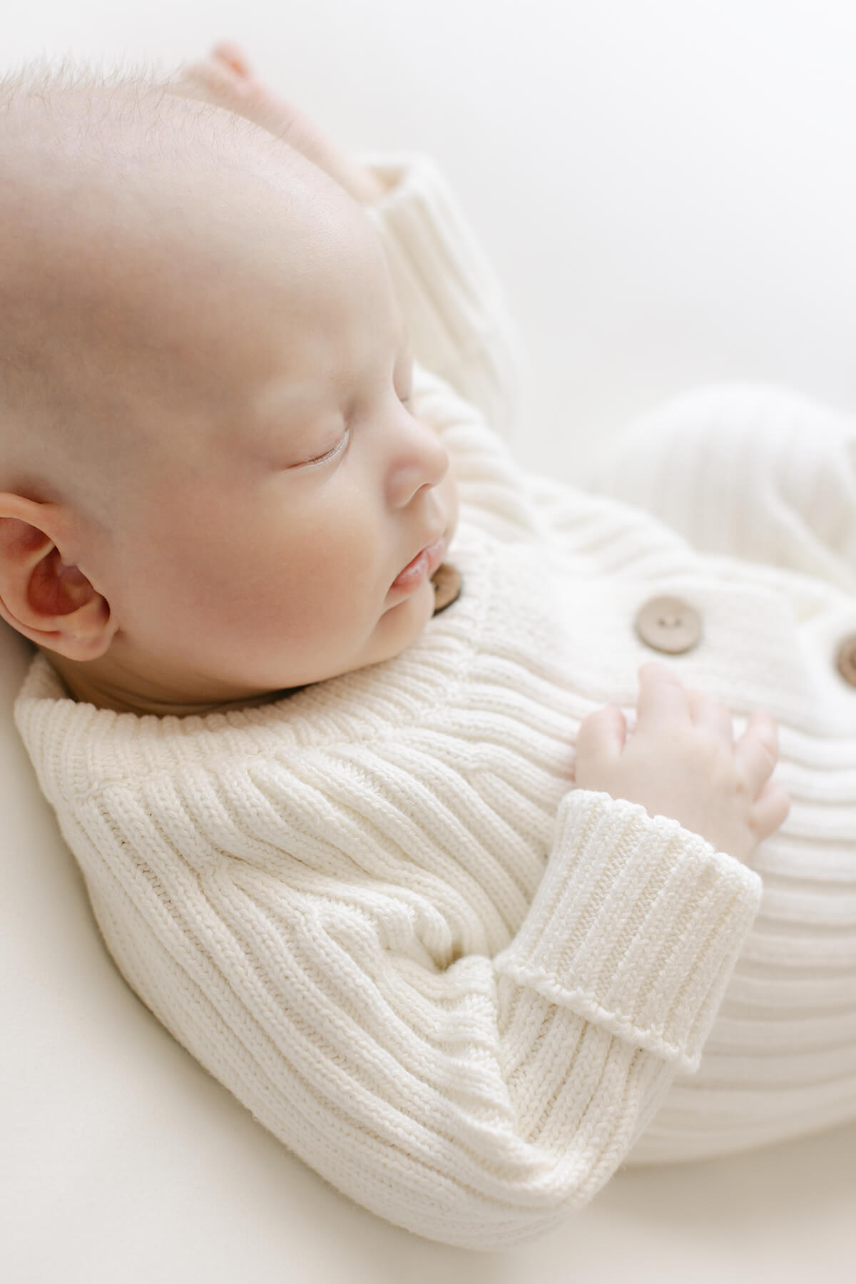 stunning image of sweet local omaha newborn wearing a knit organic romper