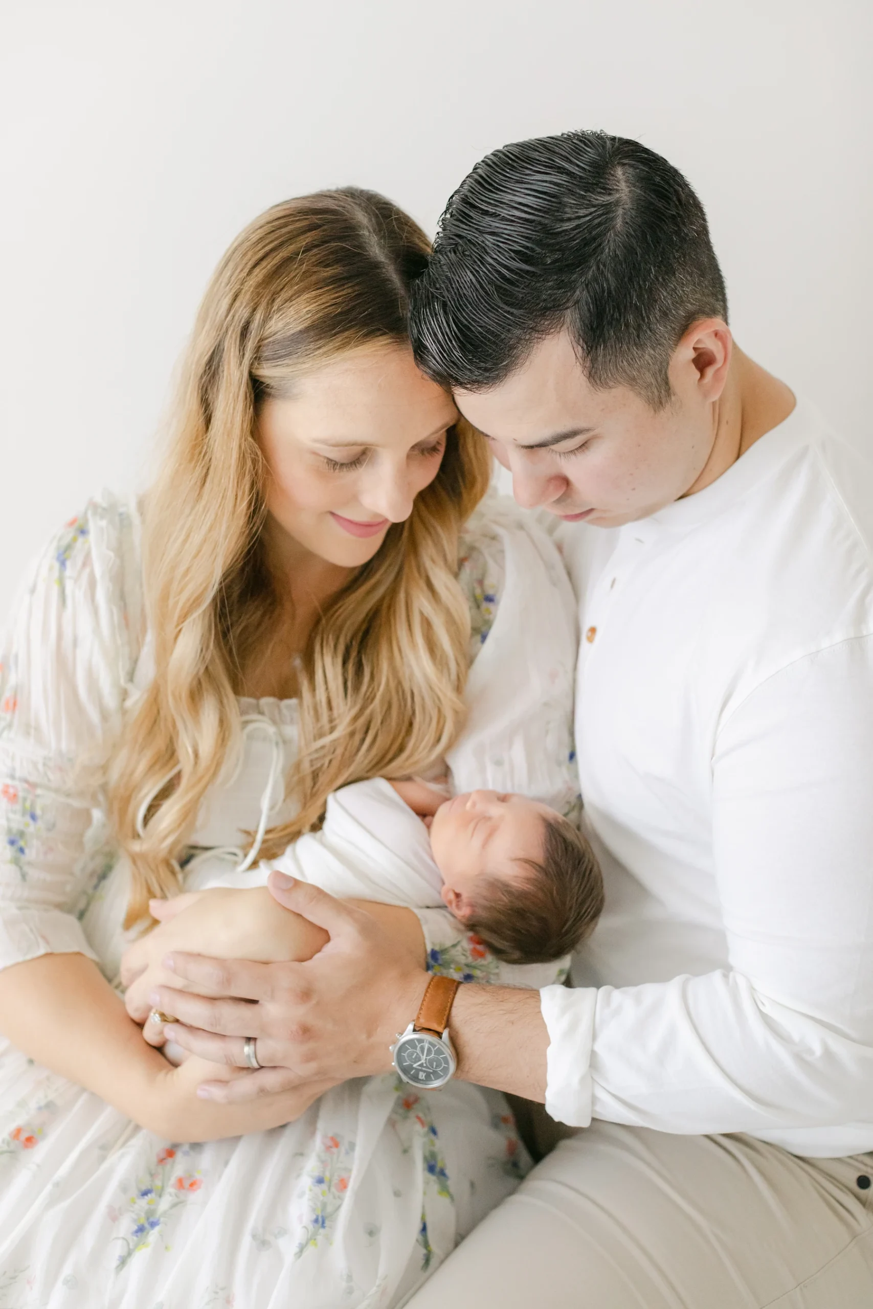Mother and father holding their newborn during a family portrait session at an Omaha studio